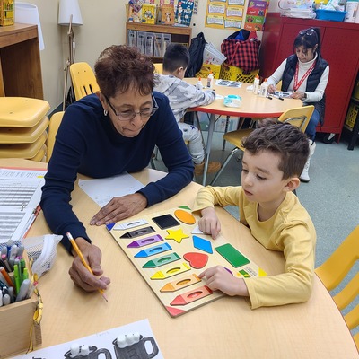 A volunteer helping a student identify colors.