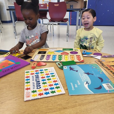 Two students playing with toys during class.