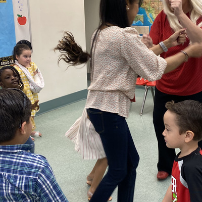 Teachers and students dancing together.
